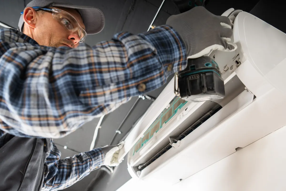 Technician installing a ductless mini split air conditioner