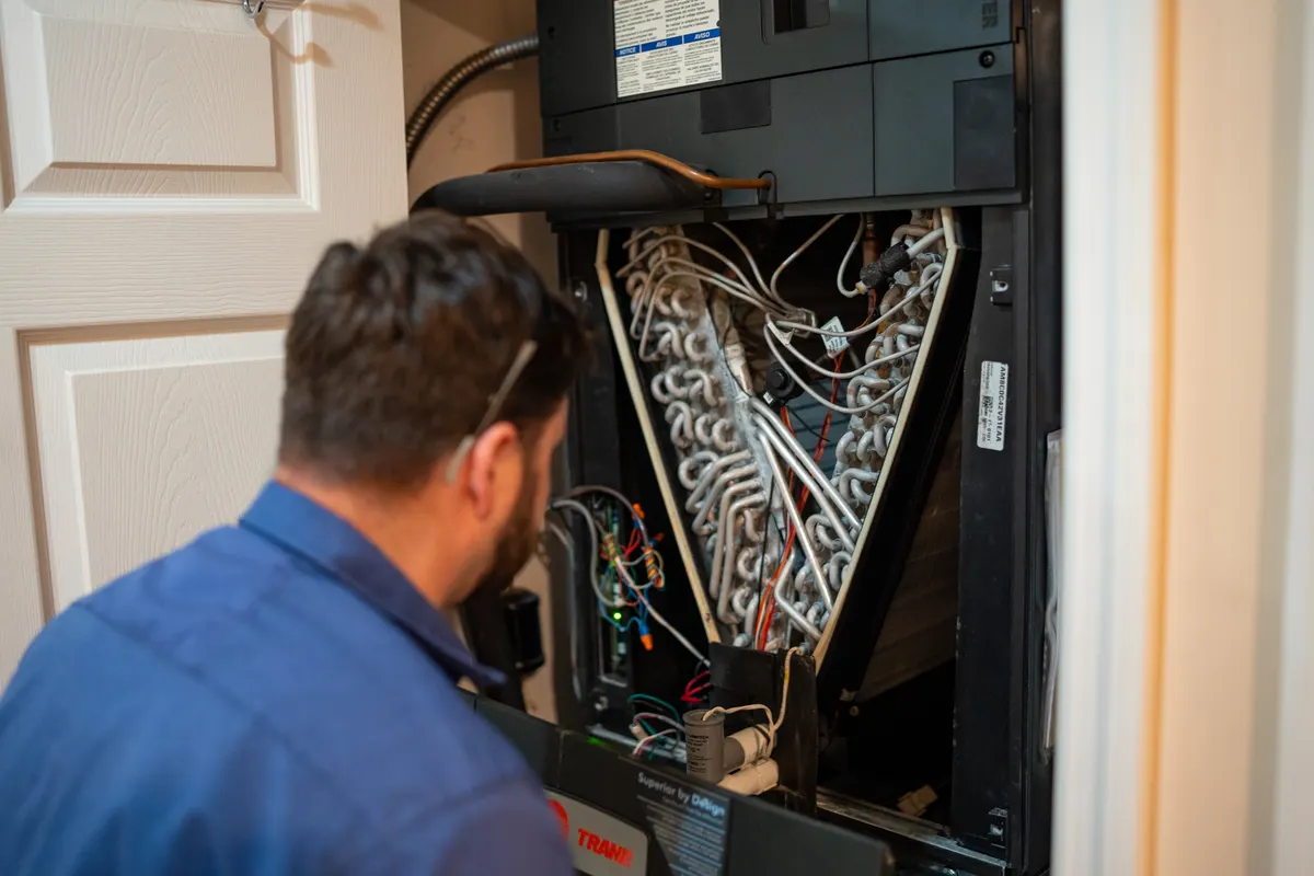 Miranda technician inspecting furnace components during repair service