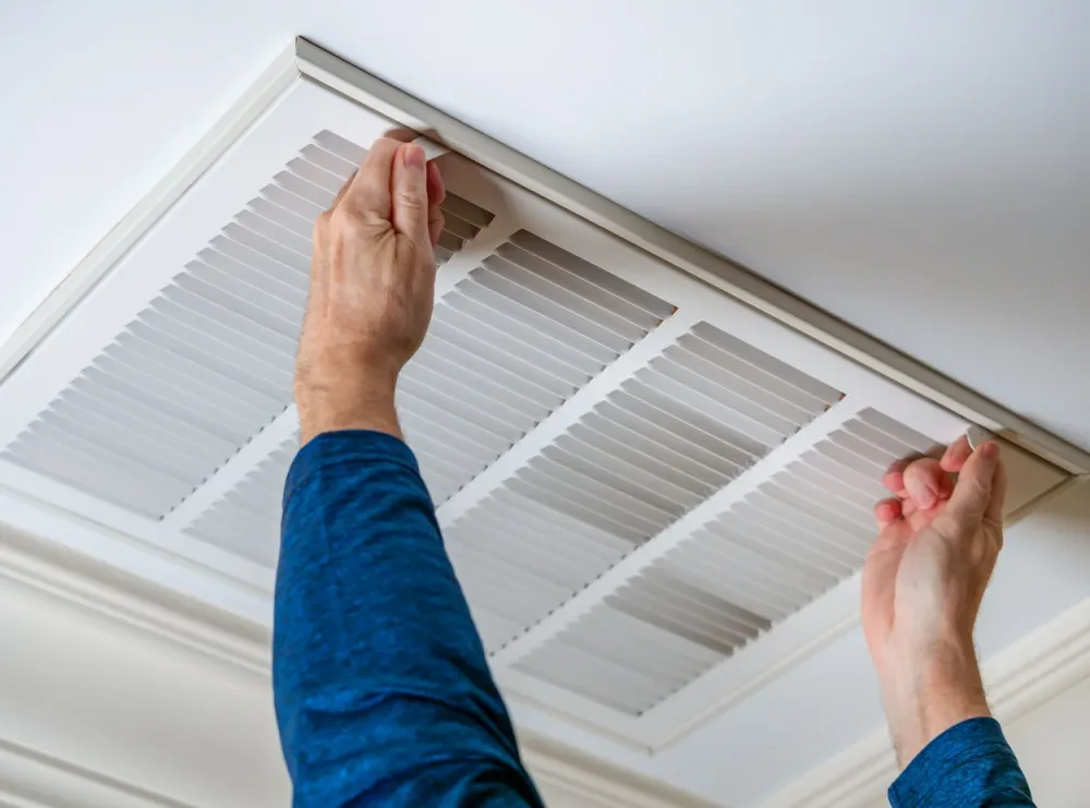 Technician cleaning air ducts in a home