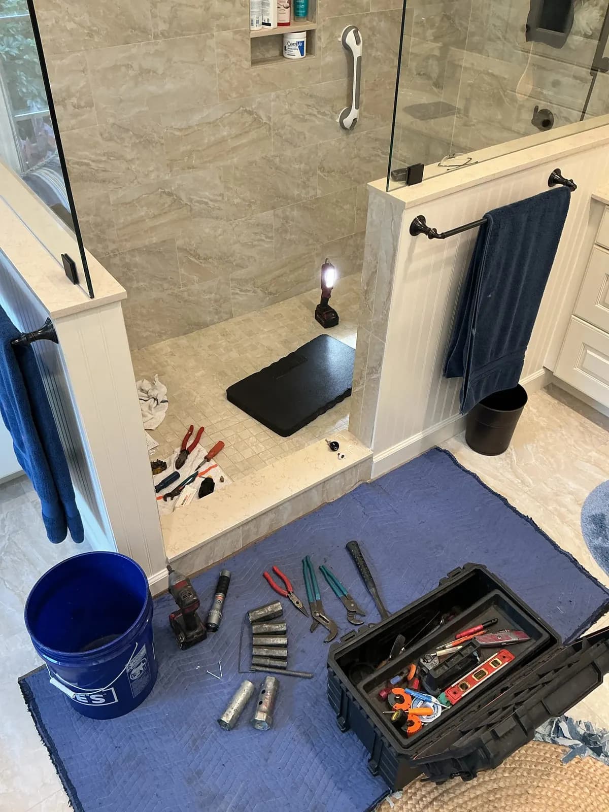 Bathroom shower repair with tools on the floor