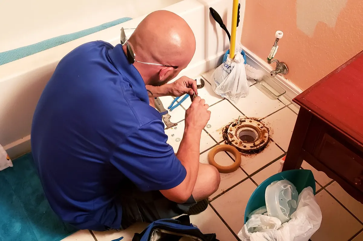 Plumber repairing a toilet flange