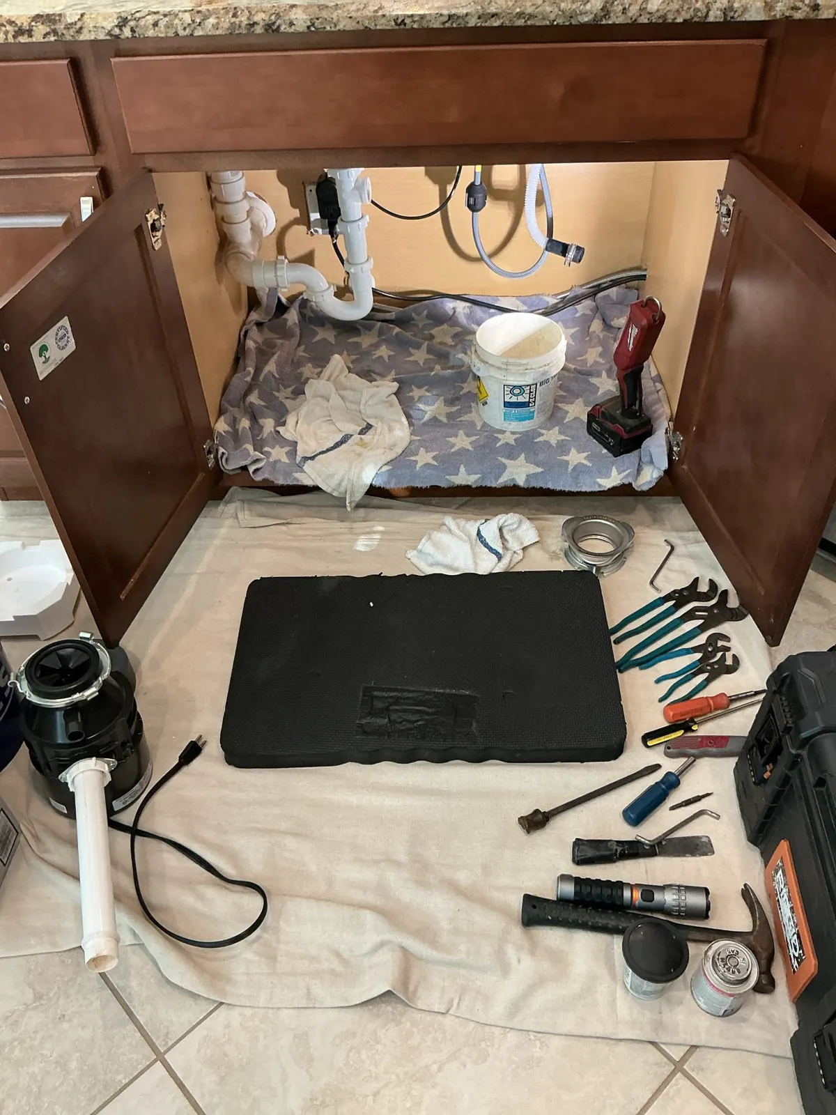 New garbage disposal installed below a kitchen sink