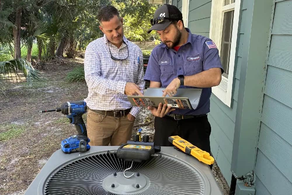 Technician points out an AC issue to a homeowner.