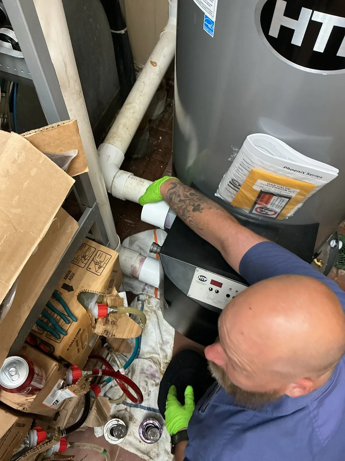 Technician repairing plumbing connections on a water heater