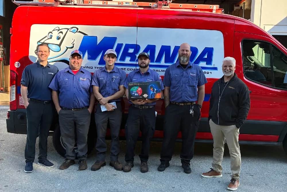 Miranda Plumbing & Air Conditioning team standing beside a service van.