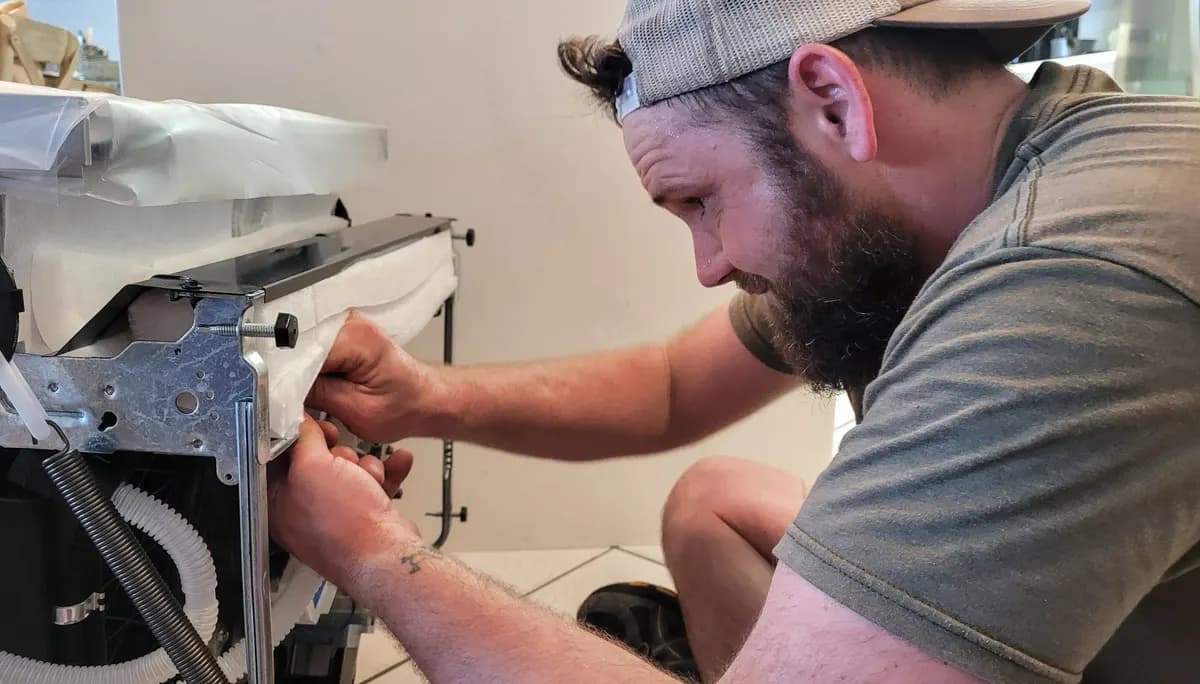 Technician repairing a dishwasher