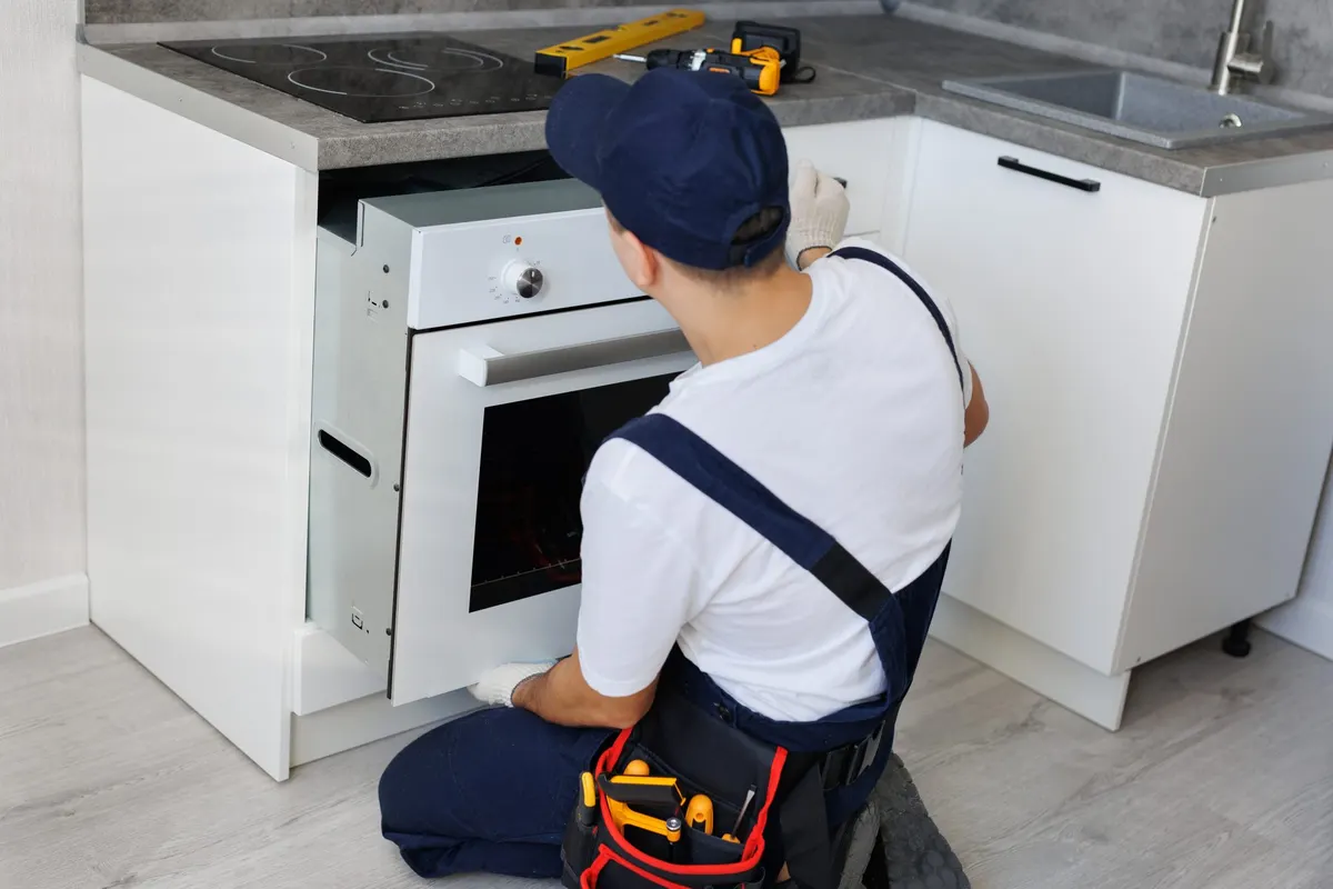 Technician installing a built-in kitchen appliance
