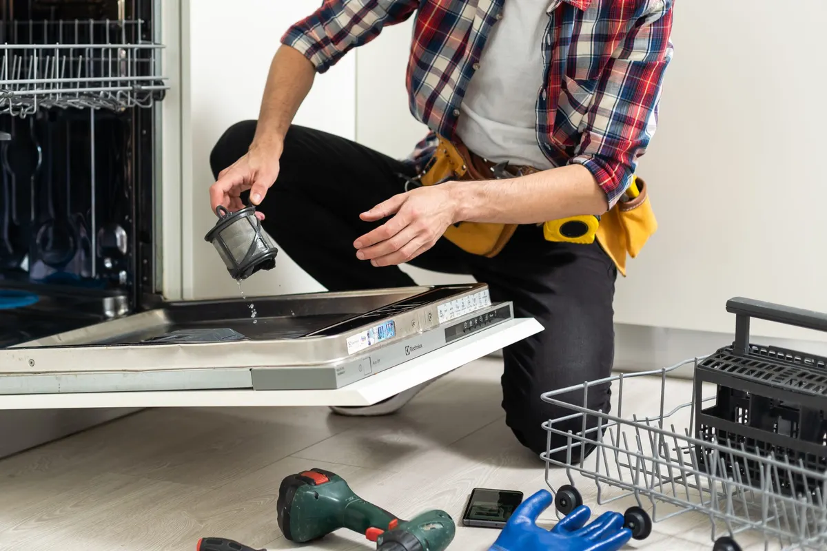 Technician cleaning a dishwasher filter
