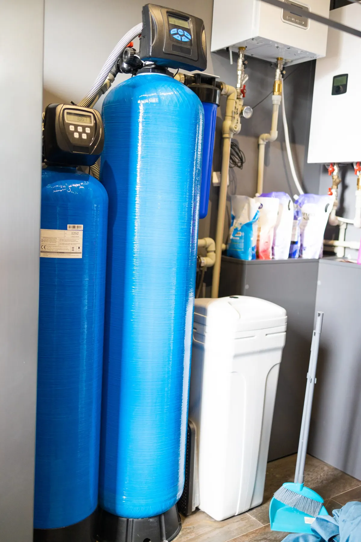 Whole-home water filtration tanks installed in a utility area