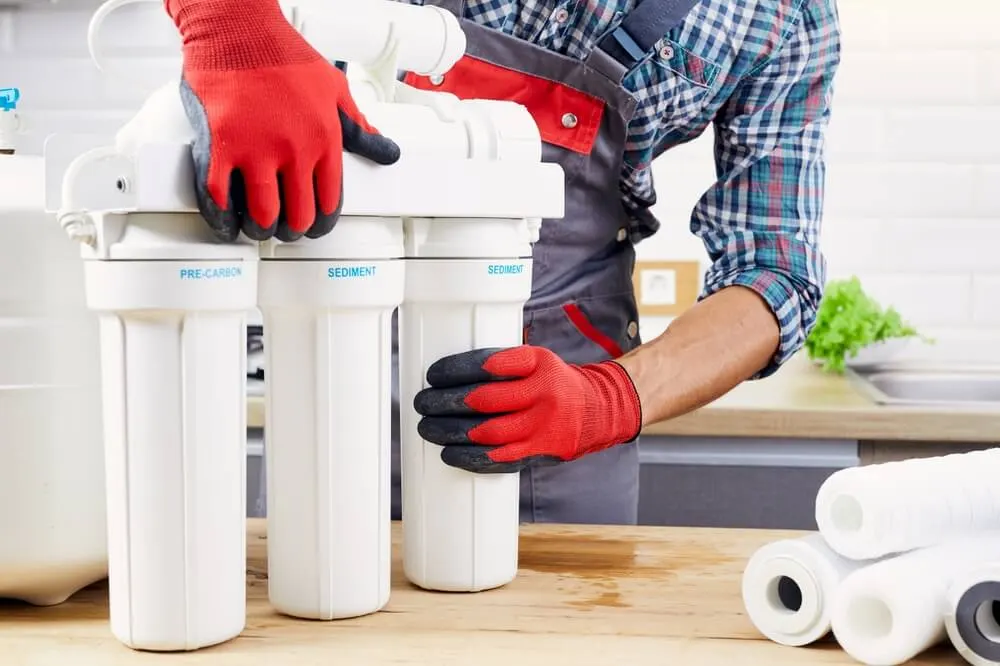 Technician installing a multi-stage water filtration system