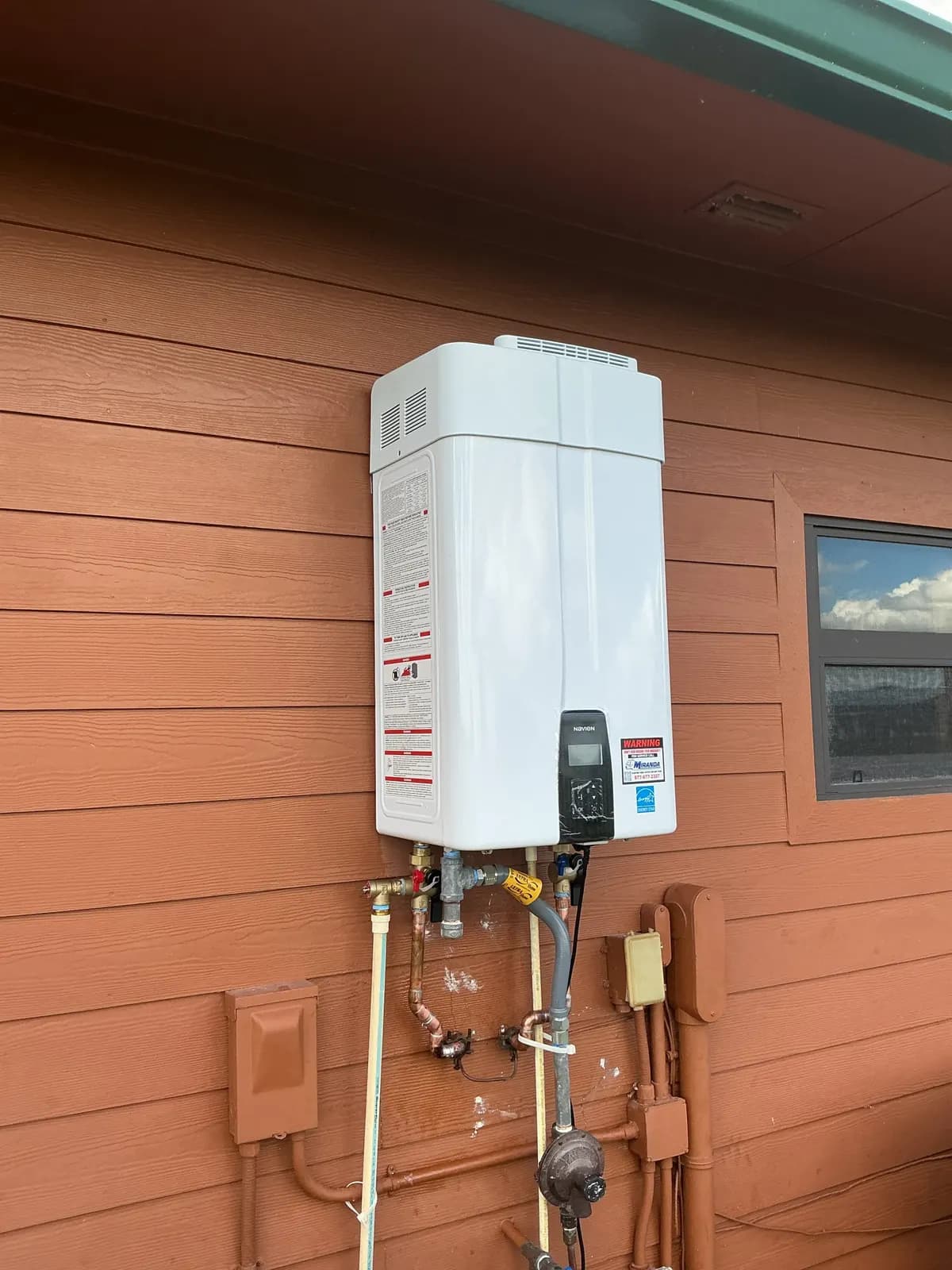 Wall-mounted tankless water heater installed outdoors